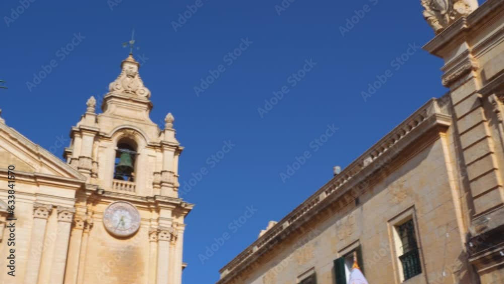 Mdina, Malta POV day pan to St Paul Baroque Catholic Cathedral with twin bell towers inside the medieval Silent City citadel. Mdina, Malta POV day pan to St Paul Baroque Catholic Cathedral with twin bell towers inside the medieval Silent City citadel.