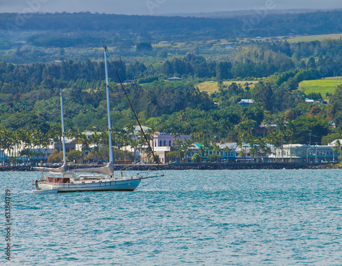 Sailboat in Hilo Bay With Downtown Hilo and The Lava Filled Shoreline Along Banyan Drive, Hilo, Hawaii Island, Hawaii, USA