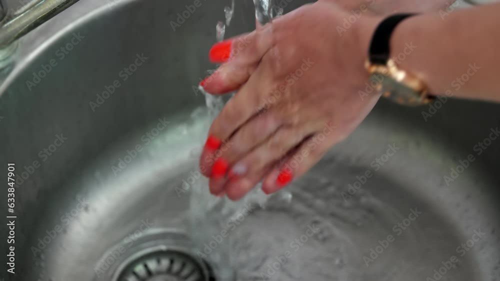 The girl opens the faucet and washes her hands with running water. Close-up of the hand of a woman who washes her hands in the sink. The girl opens the faucet and washes her hands with running water. Close-up of the hand of a woman who washes her hands in the sink.