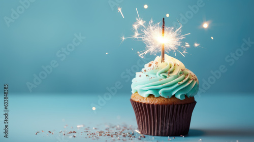 Birthday cupcake with celebration sparkler and sprinkles for a birthday party on blue background. Created with Generative AI technology.
