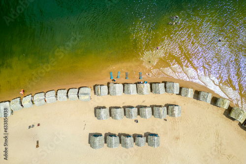 Aerial view of palm-thatched beach huts at Pindobal, a freshwater beach on the banks of the Tapajos river in Belterra, Para, Brazil. photo