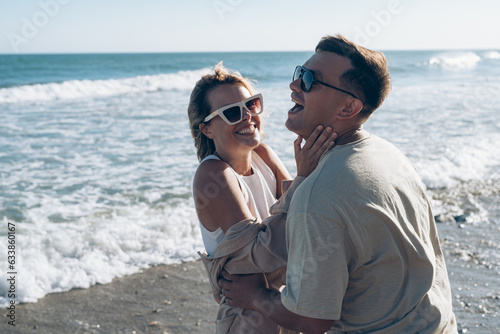 boyfriend and girlfriend husband and wife on vacation at sea have fun hugging and laughing on the beach near the sea