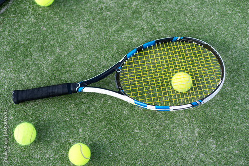 Tennis Racquet with Ball over Green Artificial Grass. Vertical Image © Angelov