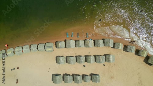 Drone aerial footage: exploring the thatched roof beach huts at Pindobal freshwater beach, alongside the Tapajos river, Belterra, Para, Brazil photo