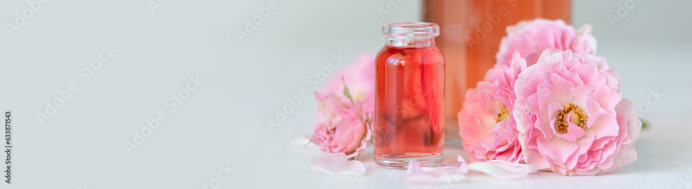 Concept of perfume with pure natural organic rose ingredient, essential oils. Glass bottles with flower herbal extract and elixir. Perfumery cosmetic toilet water fragrance, banner copy space for text Concept of perfume with pure natural organic rose ingredient, essential oils. Glass bottles with flower herbal extract and elixir. Perfumery cosmetic toilet water fragrance, banner copy space for text