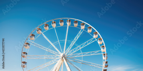 Attraction in amusement parks - Ferris wheel against bright blue sky  copy space for text. Creative minimal wallpaper for open-air amusement park.