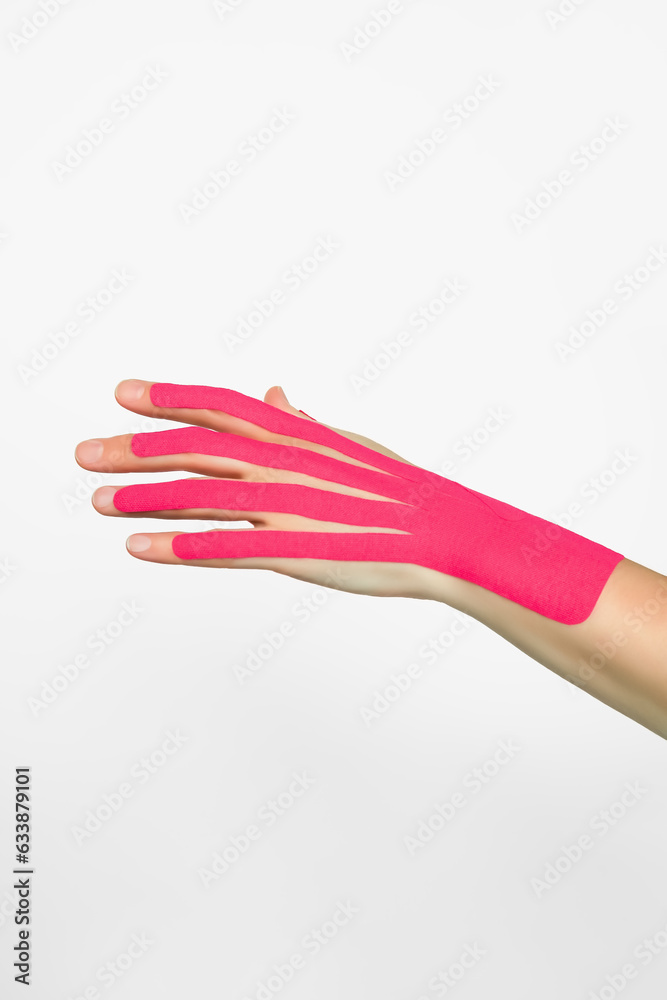 aesthetic hand taping. female hand with pink kinesio tape. hand skin care, non-surgical hand skin tightening using kinesio tapes aesthetic hand taping. female hand with pink kinesio tape. hand skin care, non-surgical hand skin tightening using kinesio tapes