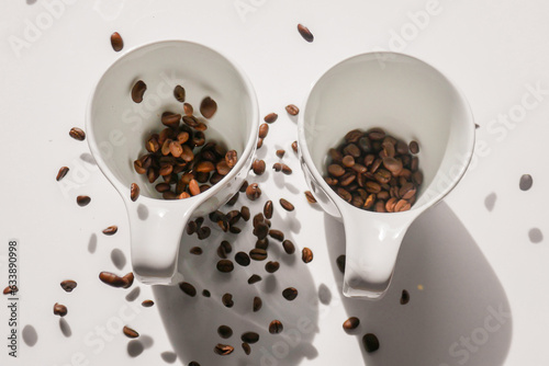 cups and falling coffee beans.coffee levitation. Coffee in white cups.Traditional morning drink.Morning refreshing drink.