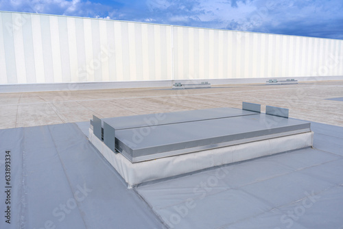 White metal sheet rooftop wall on commercial building with blue sky