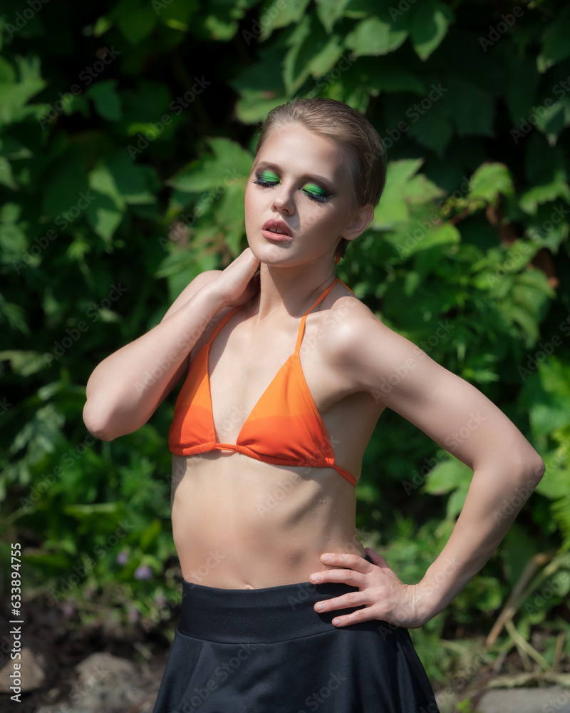 Playful sensuality adult blonde woman with short hair and bright makeup, dressed orange bikini top Playful sensuality adult blonde woman with short hair and bright makeup, dressed orange bikini top