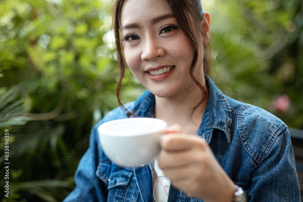 Portrait of beautiful Asian woman freelance sitting drinking coffee cappuccino in coffeeshop and smiling at camera. Portrait of beautiful Asian woman freelance sitting drinking coffee cappuccino in coffeeshop and smiling at camera.