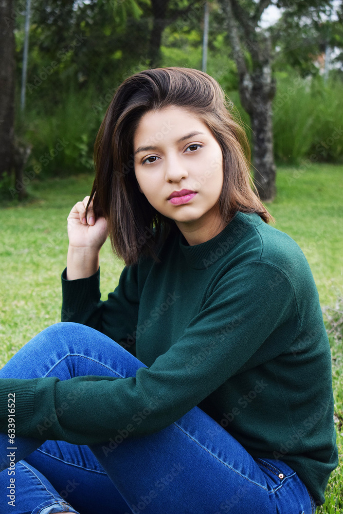 Retrato de una mujer joven Guatemalteca sentada en el césped al aire libre. Concepto de belleza latinoamericana. Retrato de una mujer joven Guatemalteca sentada en el césped al aire libre. Concepto de belleza latinoamericana.