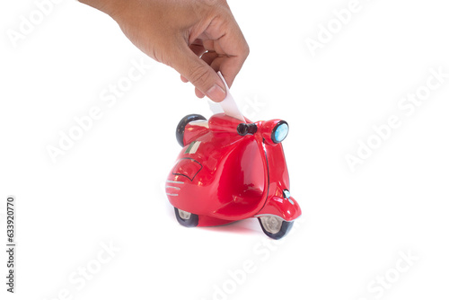 south east asian hand saving money to a ferari red scooter piggy bank in isolated white