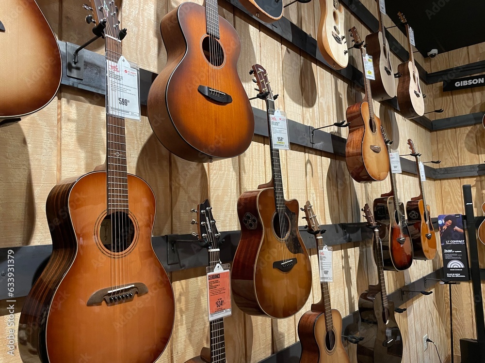 Guitar Center retail store interior wall of acoustic guitars Stock