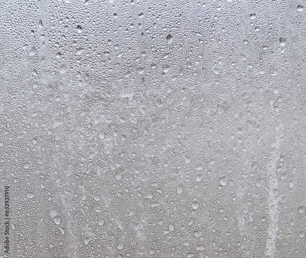 Drops of frozen water on the window glass on a cold winter day