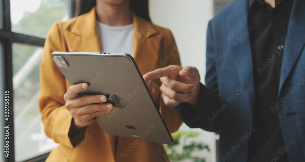 Entrepreneur Asian businessman and businesswoman discussing new business project in tablet in modern Meeting In Modern Office, Asian business casual concept. Entrepreneur Asian businessman and businesswoman discussing new business project in tablet in modern Meeting In Modern Office, Asian business casual concept.
