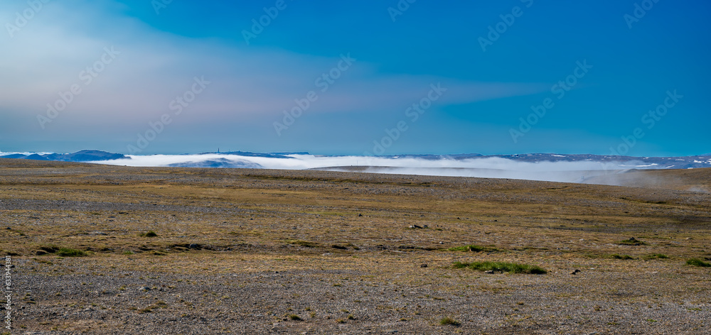 Beautiful tundra landscape with dry grass and fog in the valleys Beautiful tundra landscape with dry grass and fog in the valleys