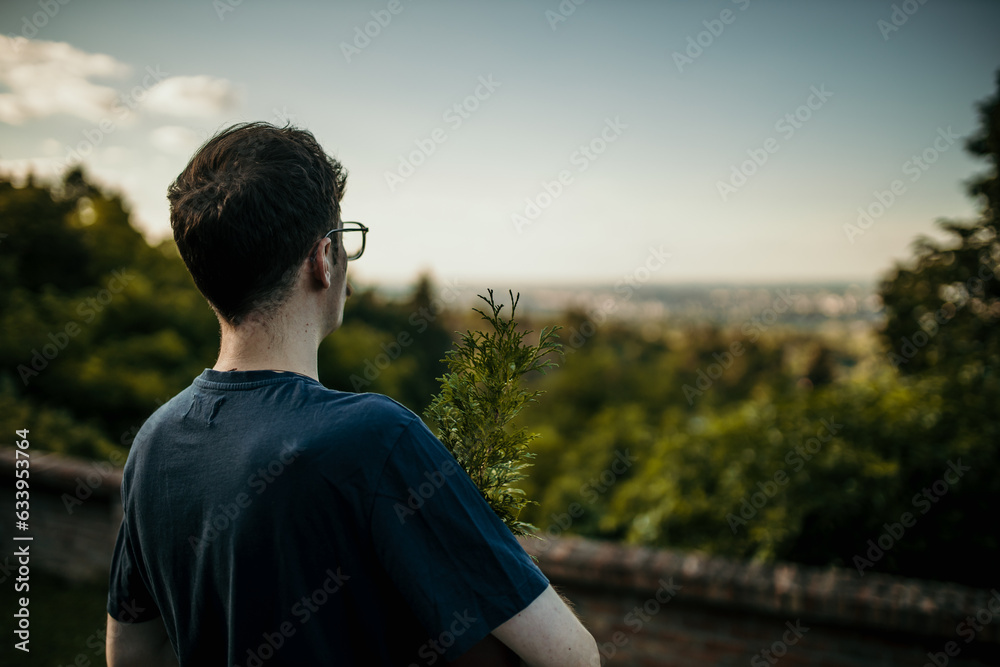 A man standing in his yard and looking at the landscape view. A man standing in his yard and looking at the landscape view.