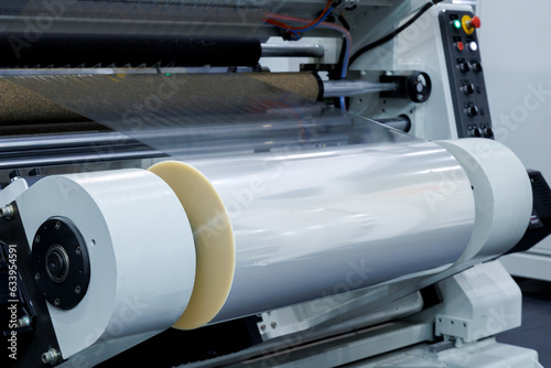 roll of plastic packaging film on the automatic packing machine in food product factory. industrial and technology concept.