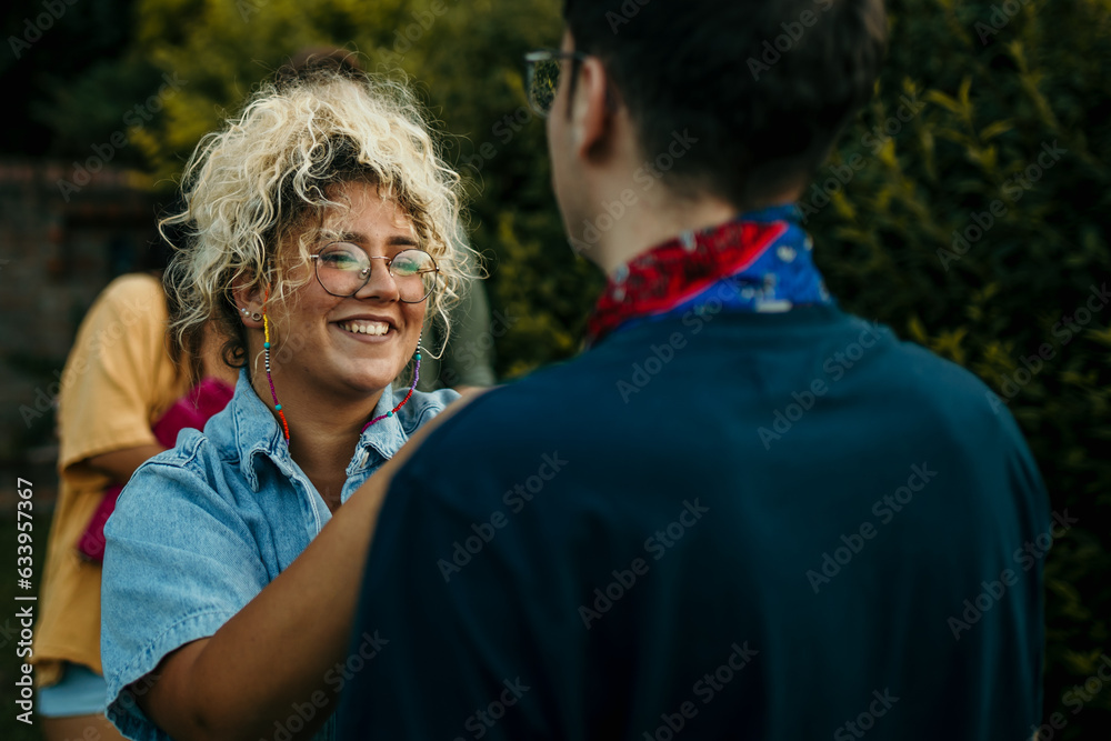 A loving couple talking, and a woman is giving a scarf as a gift to her boyfriend. A loving couple talking, and a woman is giving a scarf as a gift to her boyfriend.