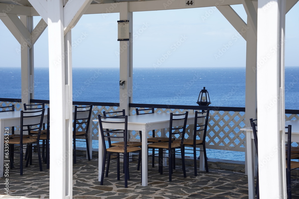 The cozy veranda of a restaurant and  turquoise colored bay of Mediterranean sea, Rhodes island, Greece