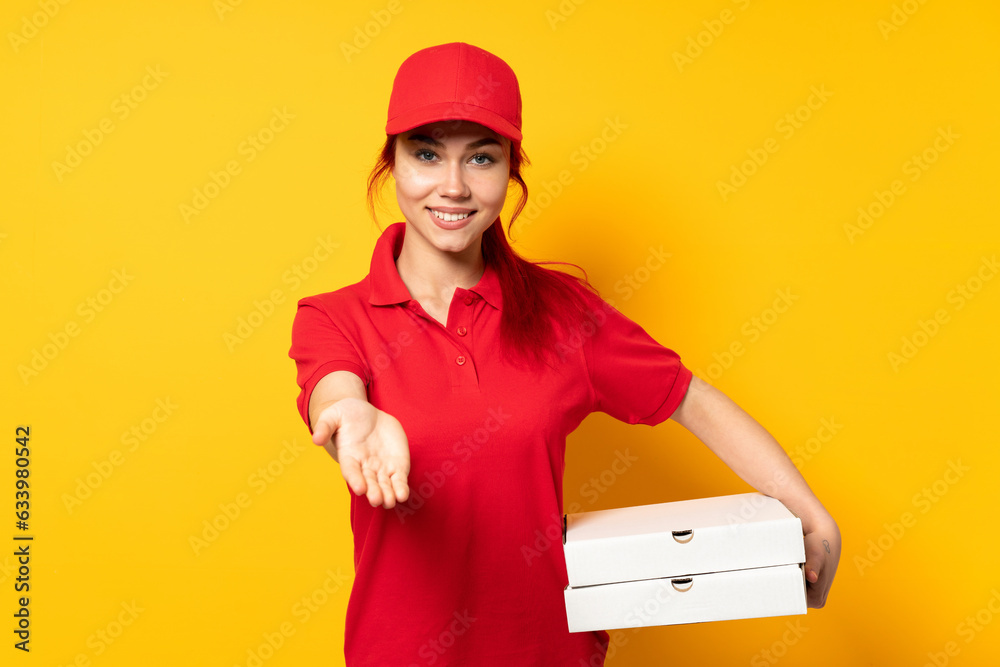 Pizza delivery girl holding a pizza over isolated background holding copyspace imaginary on the palm to insert an ad Pizza delivery girl holding a pizza over isolated background holding copyspace imaginary on the palm to insert an ad