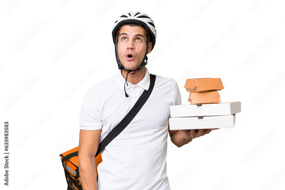 Young caucasian man with thermal backpack over isolated background looking up and with surprised expression Young caucasian man with thermal backpack over isolated background looking up and with surprised expression