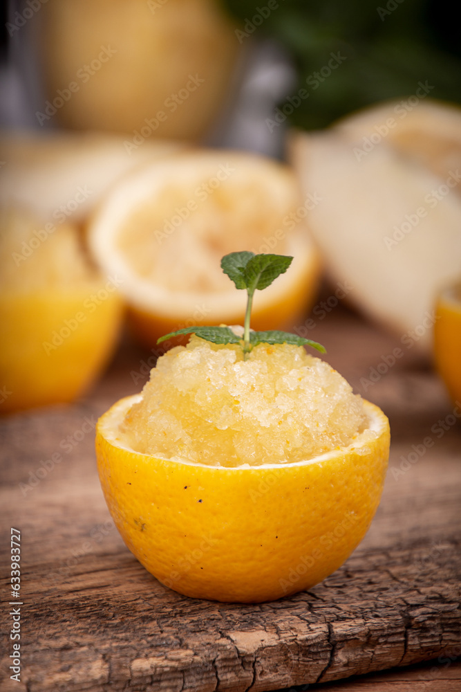 Melon and lemon fruit sorbet. Summer refreshing dessert in half of lemon fruit peel over on old wooden background. Melon and lemon fruit sorbet. Summer refreshing dessert in half of lemon fruit peel over on old wooden background.