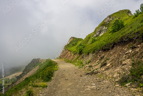 Beautiful panoramic landscape - mountain slopes and trekking trails with a large dramatic cloud and a space to copy in Krasnaya Polyana sochi russia