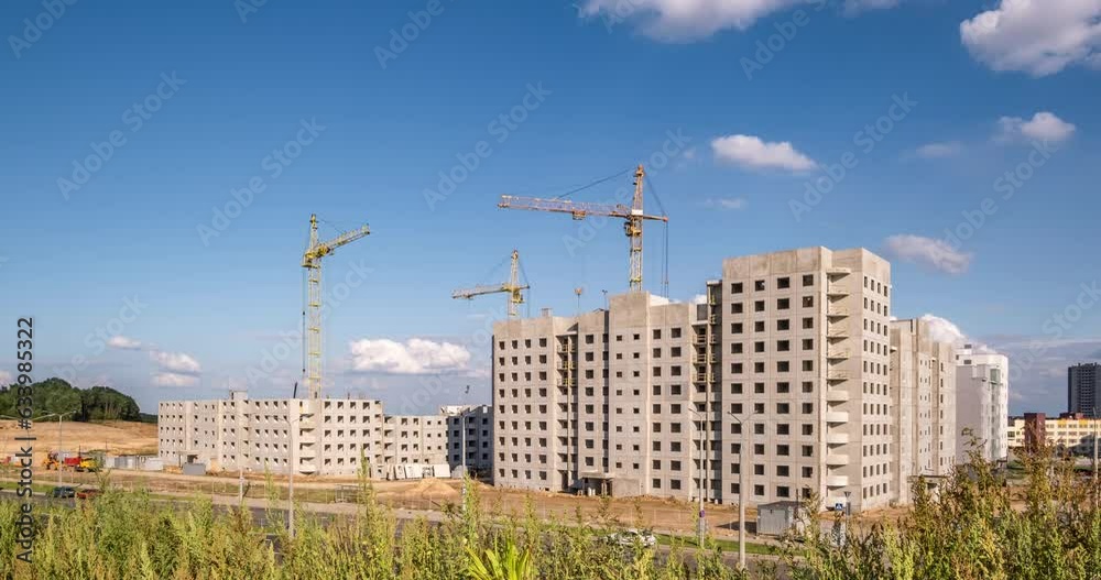time lapse of three tower cranes working on construction with blue sky and white clouds as background time lapse of three tower cranes working on construction with blue sky and white clouds as background