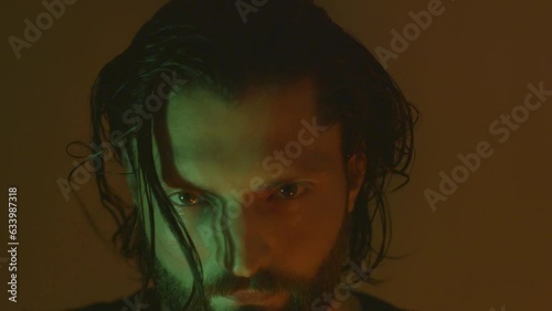 Closeup of crazy man looking at the camera and grimacing in the dark room