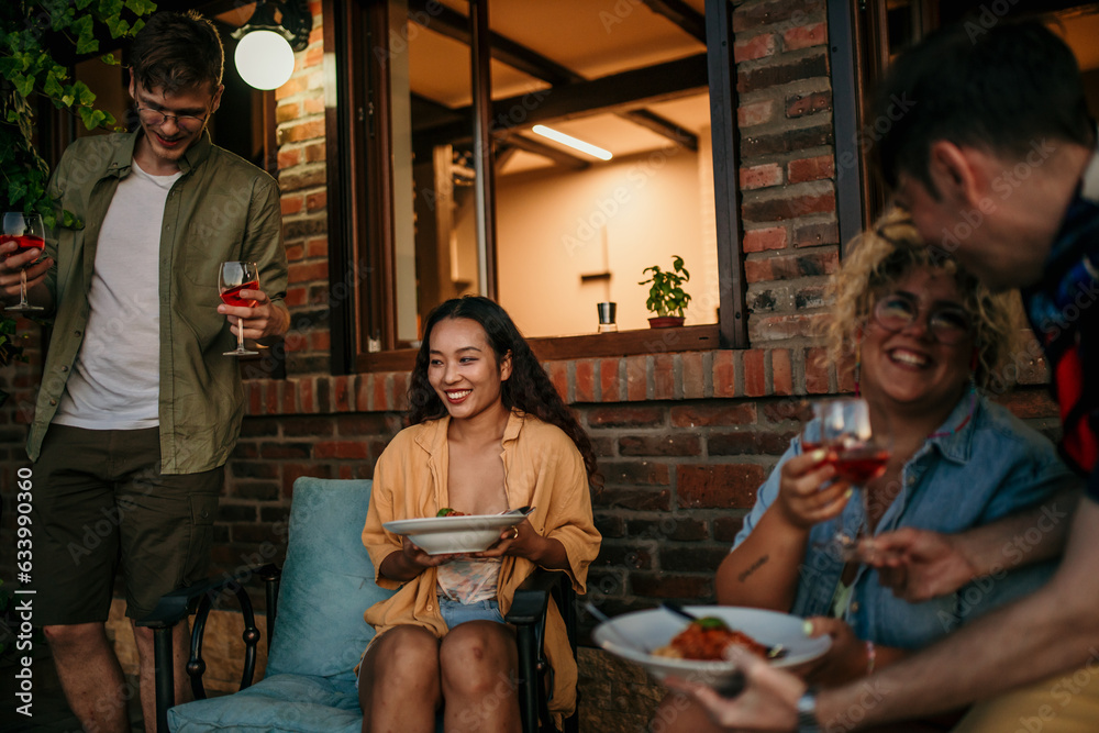 Group of diverse people sharing food and wine and spending an evening together.