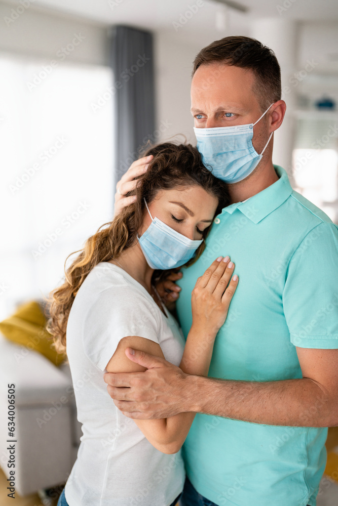 Beautiful curly brunette woman with eyes closed relaxing in her worried blue eyes man's arms. Man comforting his sick woman.