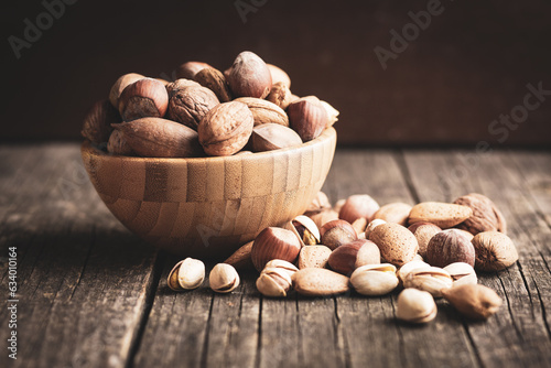 Different types of nuts. Hazelnuts, walnuts, almonds, pecan nuts and pistachio nuts in wooden bowl.