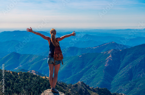 travel, tourism, adventure concept- Woman on top of mountain