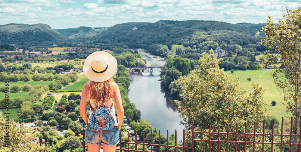 Woman tourist enjoying view of river, field and mountain landscape- Dordogne in France- tourism, travel,wanderlust concept