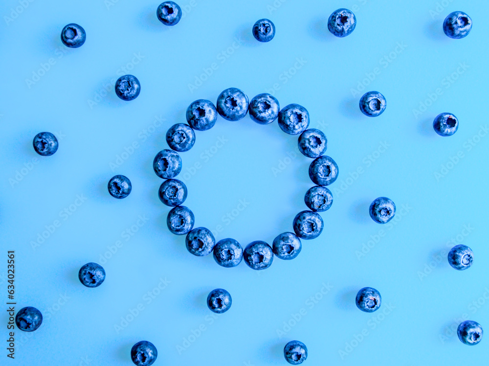 Creative summer round frame made of blueberries on bright blue background. Original blueberry decoration. Minimal summer concept. Welcome summer. Copy space. Creative summer round frame made of blueberries on bright blue background. Original blueberry decoration. Minimal summer concept. Welcome summer. Copy space.