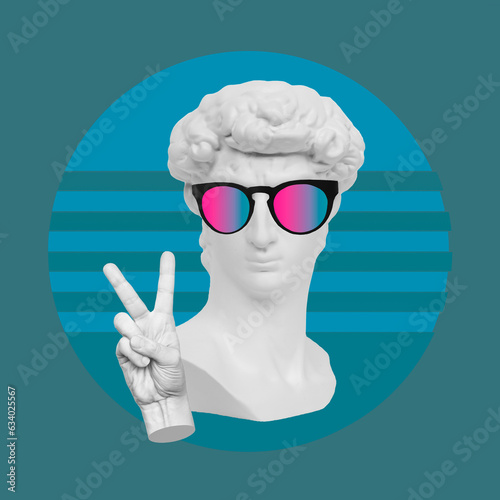 Antique male David statue's head in colorful sunglasses showing a peace gesture with hand on blue green color background. Trendy collage in magazine surreal style. Contemporary art. Modern design