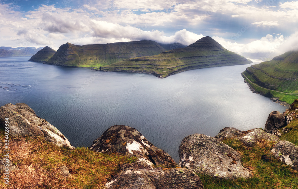 Mountain landscape panorama with ocean. Fog over the Funningur fjord on Eysturoy Island, Faroe Islands.