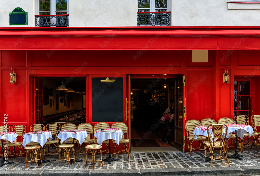 Fototapeta premium Cozy street with tables of cafe in quarter Montmartre in Paris, France. Architecture and landmark of Paris. Paris cityscape.