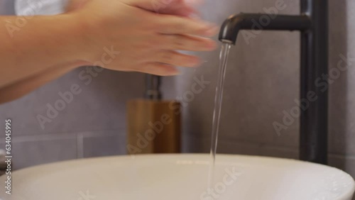 person washing hands in sink