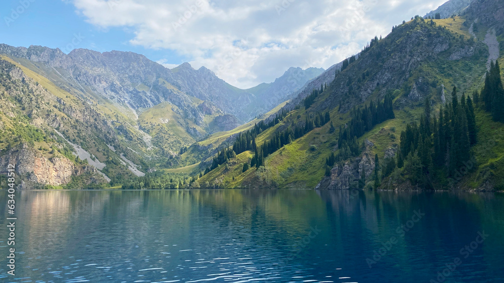 Amazing view of the green wooded hills, mountains and rocks at the beautiful lake Sary Chelek. The State Biosphere Reserve is a specially protected natural territory of Kyrgyzstan.