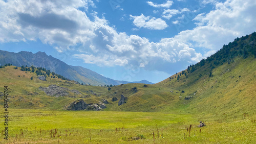 Endless fields, green hills, rocks and mountains of Kyrgyzstan. Amazing mountain summer landscape. Specially protected natural territory of Kyrgyzstan.