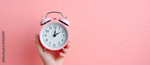 Obraz na plátně Minimal concept Woman holding alarm clock on pink background