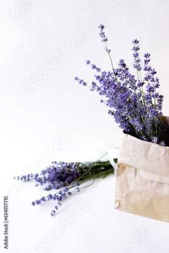 Lavender flowers in a craft paper bag on a white background.