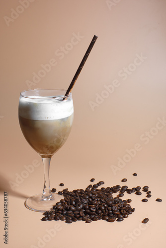 iced cappuccino with coffee beans isolated on brown background 