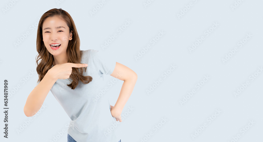 Beautiful young Asian woman pointing up to copy space and looking at camera with smile face and happy Pretty girl act like a satisfied product, use for advertising with isolated on pastel light blue Beautiful young Asian woman pointing up to copy space and looking at camera with smile face and happy Pretty girl act like a satisfied product, use for advertising with isolated on pastel light blue