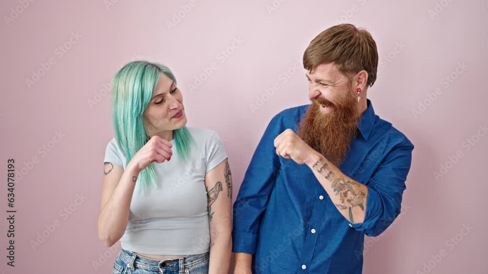 Man and woman couple smiling confident bumping fists over isolated pink background Man and woman couple smiling confident bumping fists over isolated pink background
