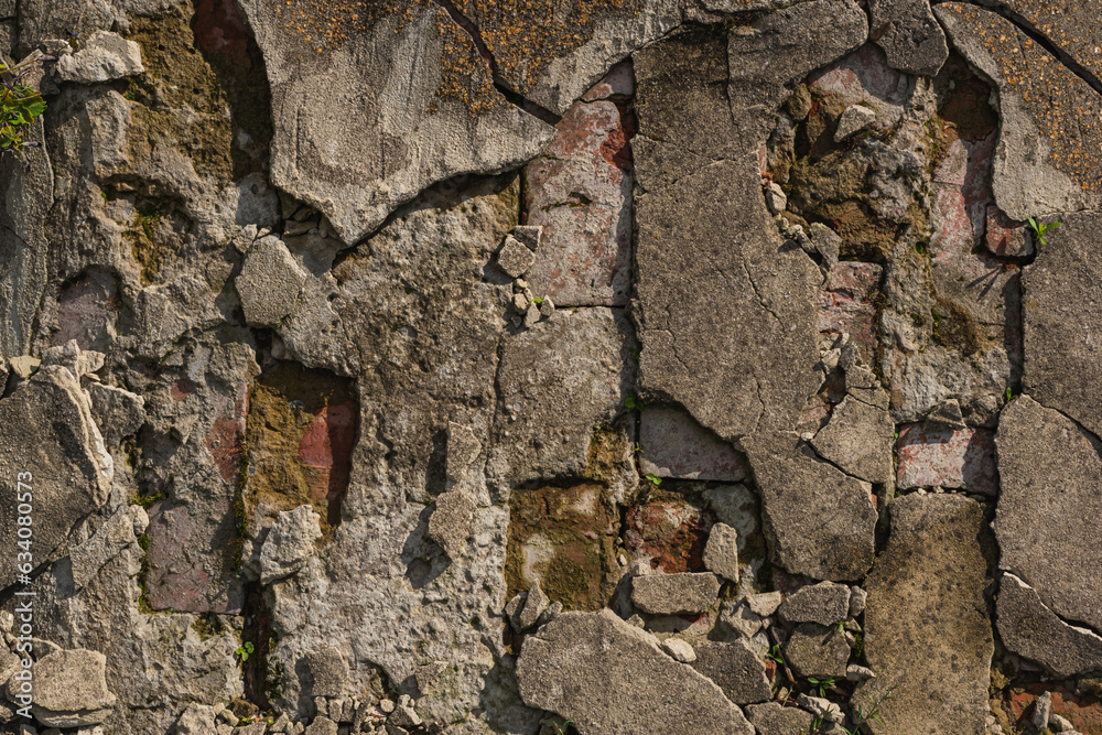 Fototapeta premium Cracked brickwork with broken shards of concrete pavement, which has come to look like this due to different weather conditions