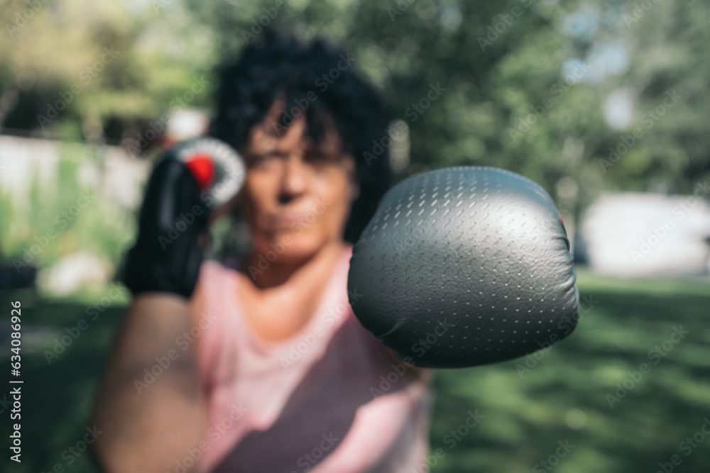 Female athlete with street boxing gloves in guard position with one ...